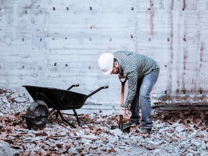 Commercial demolition contractor using specialized equipment to demolish a large building