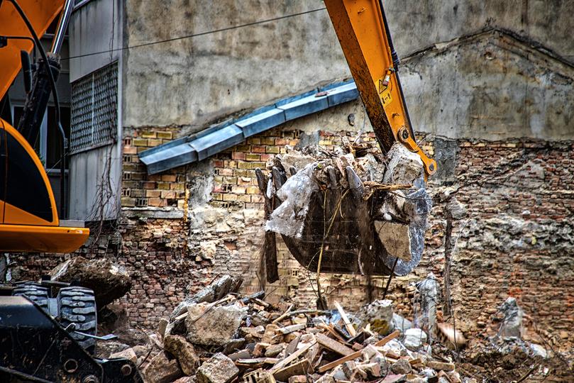 House being demolished by an excavator