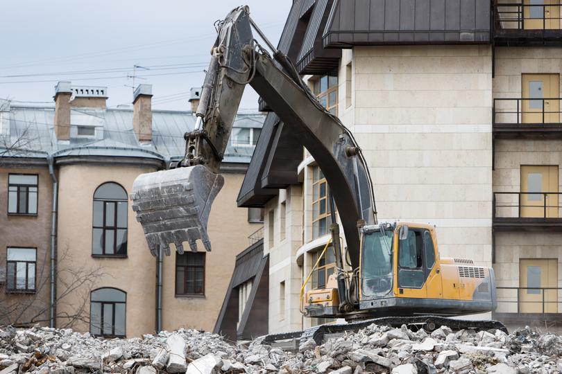 House being demolished by an excavator