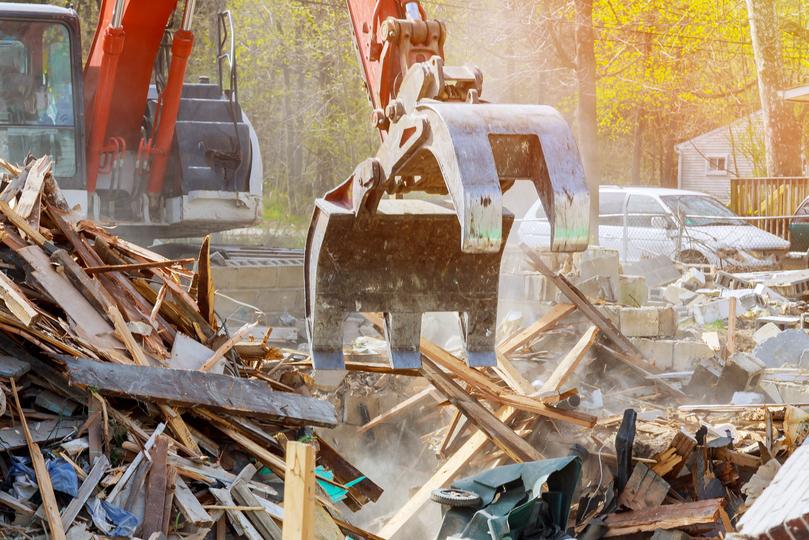 House being demolished by an excavator