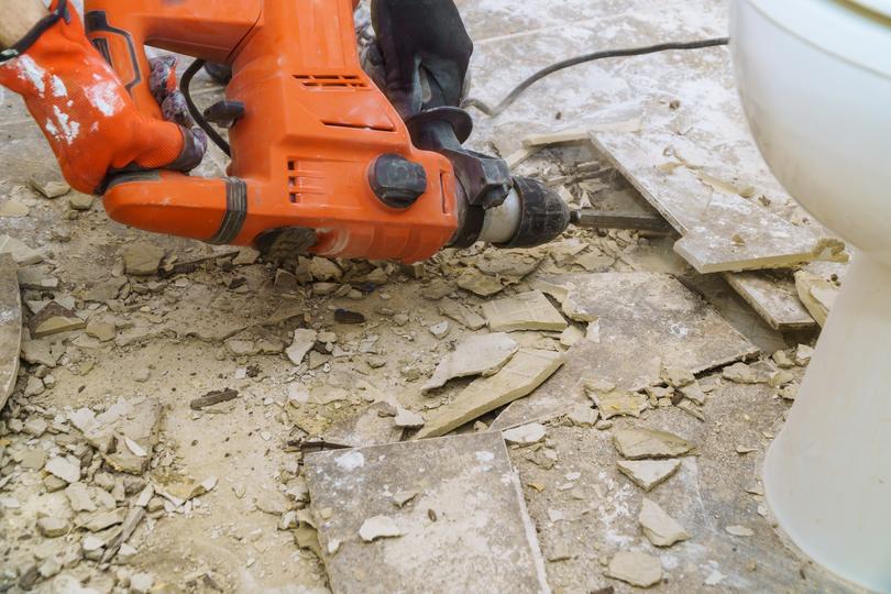 Worker operating a jackhammer for concrete demolition