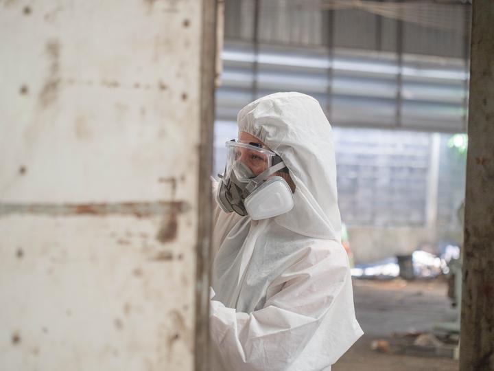 Workers in hazmat suits removing asbestos