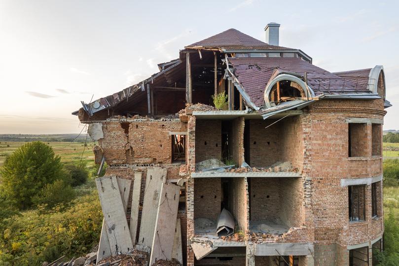 House being demolished by an excavator