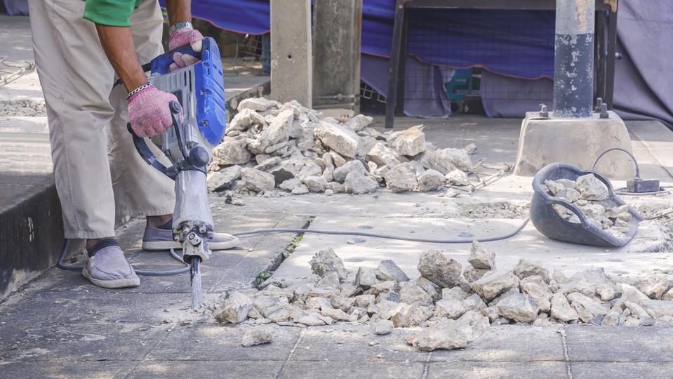 Commercial demolition contractor using specialized equipment to demolish a large building