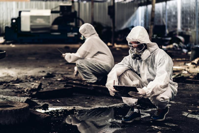 Workers in hazmat suits removing asbestos