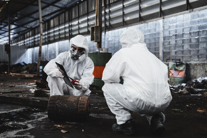 Workers in hazmat suits removing asbestos