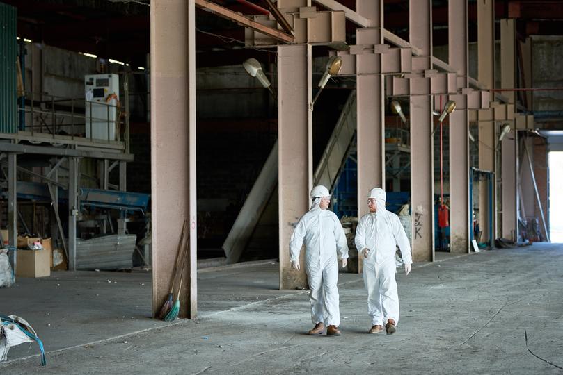 Workers in hazmat suits removing asbestos